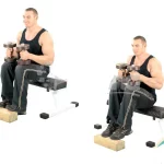 Gemelo sentado con mancuernas en las rodillas